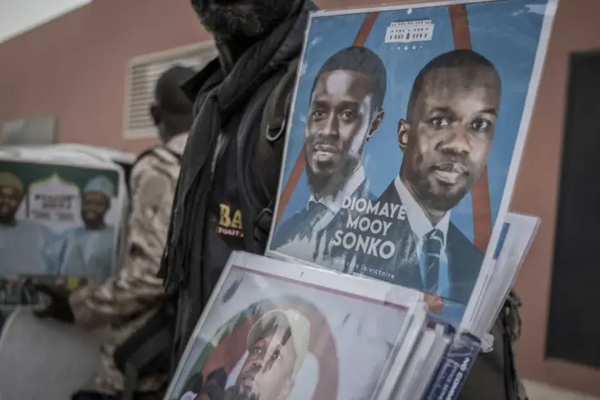 Un vendeur propose des produits dérivés en soutien à Ousmane Sonko, chef de l'opposition sénégalaise, et à Bassirou Diomaye Faye, candidat à la présidentielle, devant le lieu d'une conférence de presse à Dakar, au Sénégal, le vendredi 15 mars 2024.