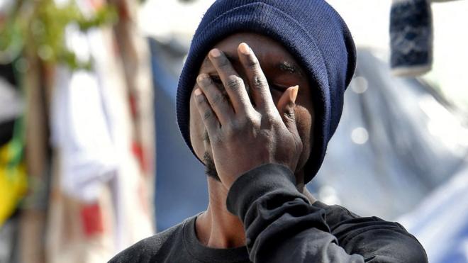 Un migrant se couvre le visage devant le siège de l'Organisation internationale pour les migrations (OIM) à Tunis, le 7 mars 2023.
