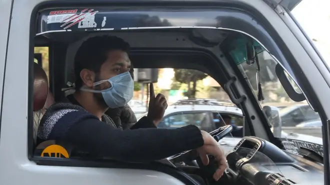 أشخاص يرتدون قناعات للوقاية من فيروس كورونا، في العاصمة المصرية القاهرة