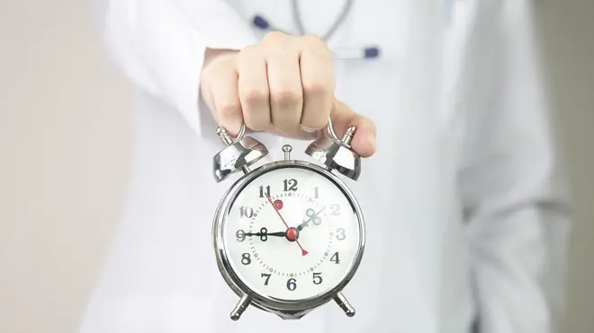 Médico sostiene un reloj