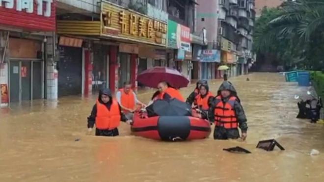 广东暴雨洪水救援人员使用救生艇运输受灾群众