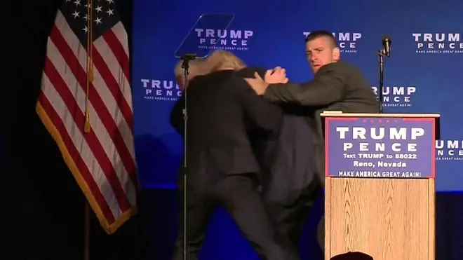 رجال الخدمة السرية يجلون مرشح الحزب الجمهوري للانتخابات الرئاسية الأمريكية دونالد ترامب بعيدا عن المنصة خلال تجمع انتخابي في مدينة "رينو" بولاية نيفادا بسبب مخاوف أمنية.