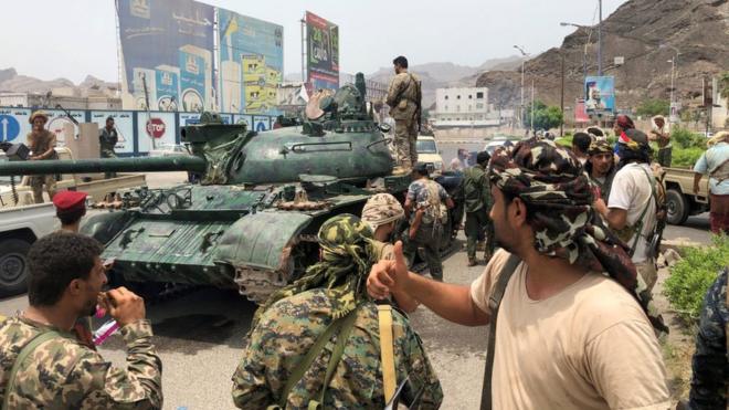 يمنيون مناصرون لحركة انفصالية جنوبية إلى جوار دبابة استحوذوا عليها من قاعدة عسكرية قريبة في مدينة عدن الجنوبية في 10 أغسطس/آب 2019