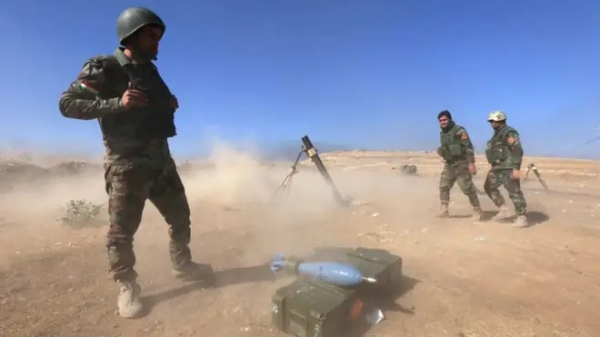 Iraqi Kurdish Peshmerga fighters fire a mortar shell from the top of Mount Zardak, about 25 kilometres east of Mosul