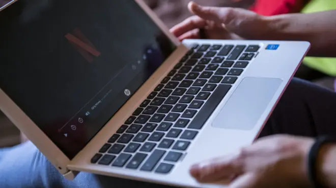 a woman watches netflix on her laptop