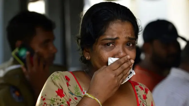 遇难者家属认领亲人遗体时，不禁掩脸落泪。