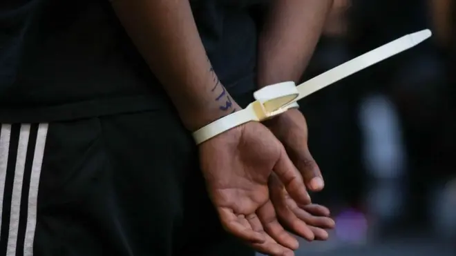 On close up view of one man hands in plastic handcuffs