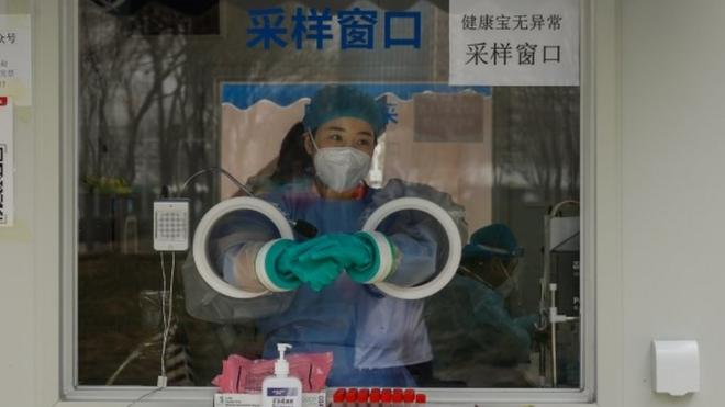 A health worker closes a vial after conducting a COVID-19 test in Beijing, China, 11 April 2022. Shanghai recorded 26,087 new cases making it the fourth consecutive day recording more than 20,000 cases