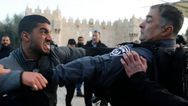 ایک فلسطینی شخص اسرائیلی اہلکار سے لڑ رہا ہے