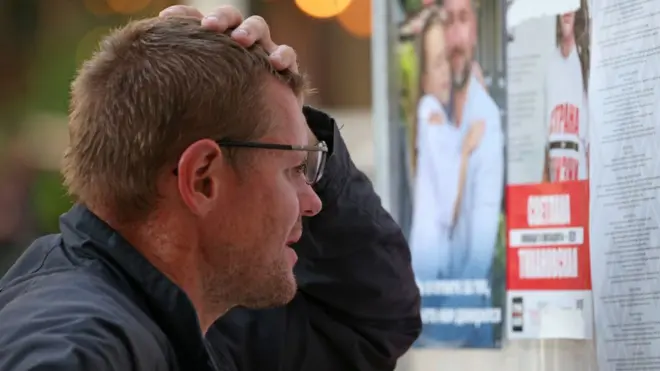 Мужчина перед стендом с предвыборными листовками