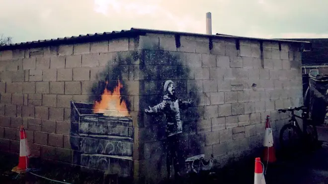 Banksy melukis di dua sisi dinding bangunan garasi mobil di sebuah permukiman di wilayah Port Talbot, Wales.