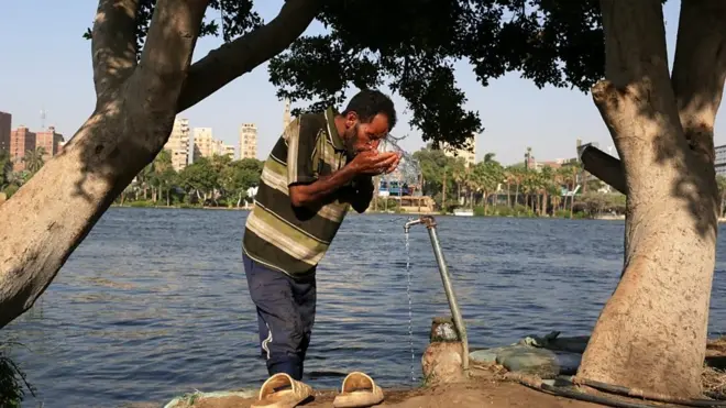 رجل مصري يشرب الماء أثناء النهار فيما تعيش مصر والدول العربية موجة صيفية حارة