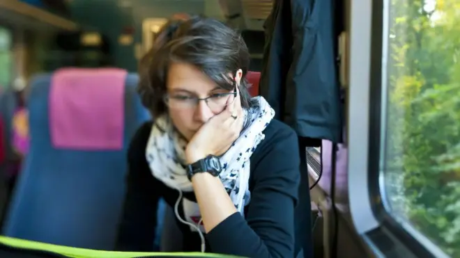 Seorang perempuan bekerja di dalam gerbong kereta.