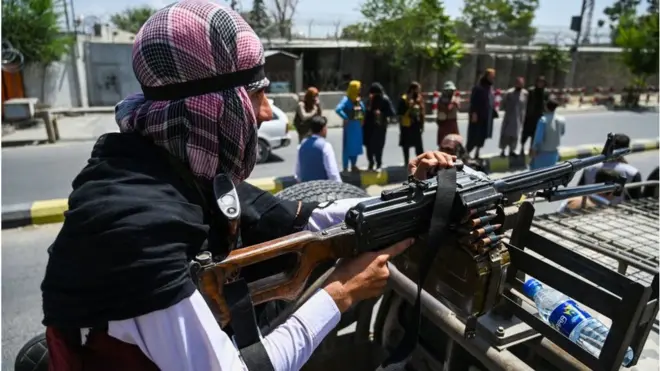 Seorang milisi Taliban memegang sepucuk senjata api di atas sebuah mobil yang sedang berpatroli di jalan Kota Kabul, Senin (16/08).