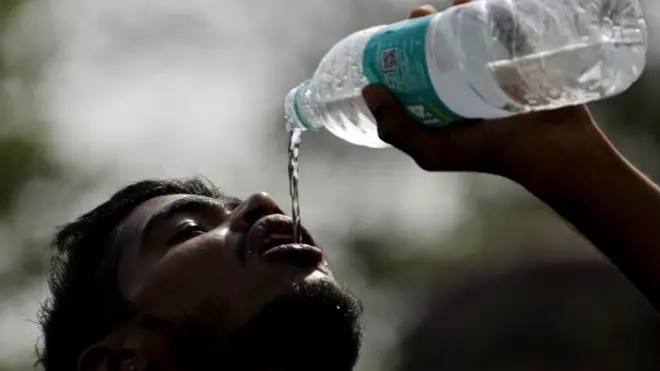 boy drinking from a bottle of water