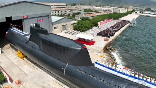 People attend what North Korean state media report was the country's launching ceremony for a new tactical nuclear attack submarine