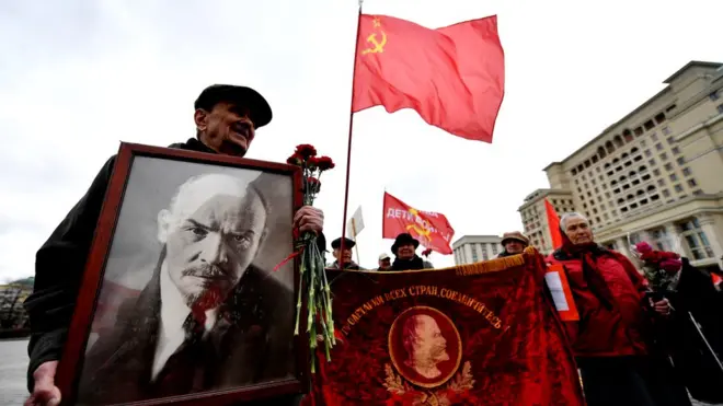 Người dân Nga vác cờ, hoa và ảnh Lenin trong một sự kiện đánh dấu 147 năm ngày sinh của cố lãnh tụ cách mạng tháng Mười của Nga
