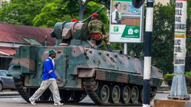 Мужчина на фоне бронетехники в Хараре