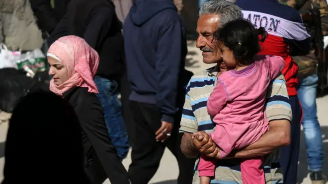 People wait to leave the rebel-held Barzeh district of Damascus (8 May 2017)