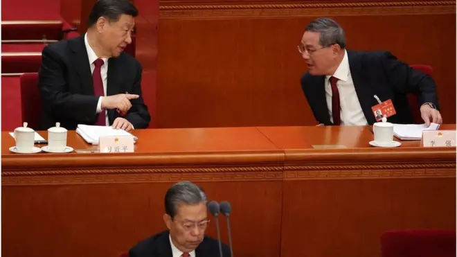 中國人大十四屆二中全會開幕式上，中國國家主席習近平（後左）與國務院總理李強（後右）講話，前面是全國人大常委會委員長趙樂際。