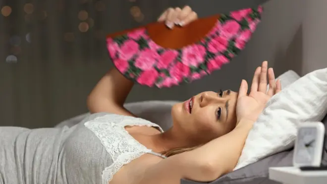 Una mujer se abanica para tratar de dormir