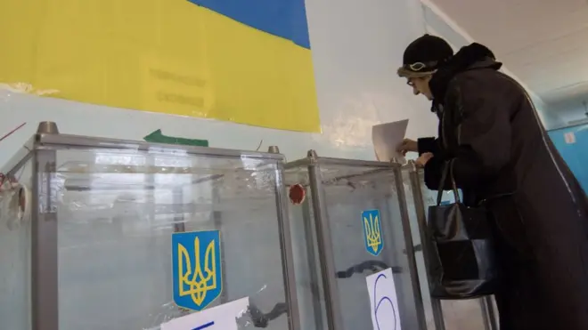 Жінка вкидає бюлетень у скриню