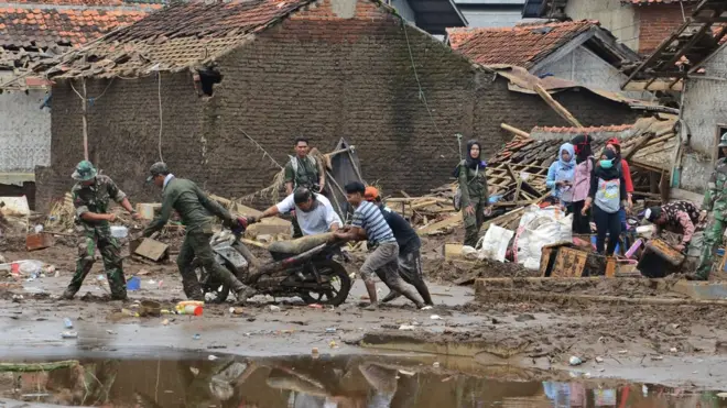 Aparat TNI dan warga berupaya untuk mengevakuasi motor dari wilayah banjir dan tanah longsor di Garut Jabar (23/09).