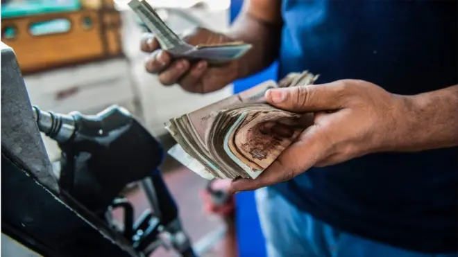 رجل مصري يحاسب عند محطة وقود