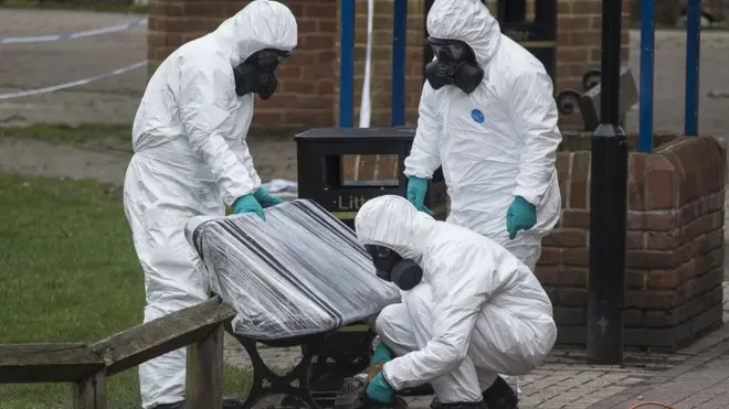 身着防化服装的英国警方调查人员将前间谍谢尔盖·斯克里帕尔和女儿尤利娅被发现昏迷的一个餐馆外长凳移走检查。