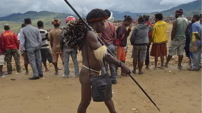 Seorang warga suku Dani berjalan melintasi kerumunan di sela-sela Festival di lembah Baliem di Distrik Walesi, Wamena, Provinsi Papua Province, Agustus 2016 lalu.