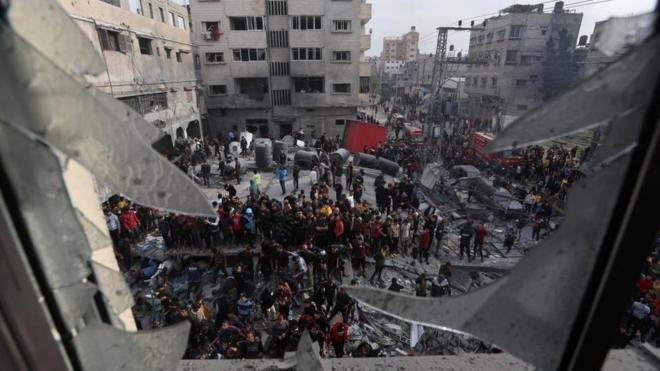 イスラエルに空爆された住宅の周りに集まる人たち（20日、ガザ地区南部ラファ）