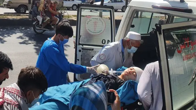 Relatives and medical staff shift a wounded girl from an ambulance outside a hospital in Kabul