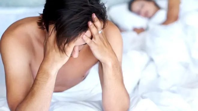 Hombre preocupado en la cama