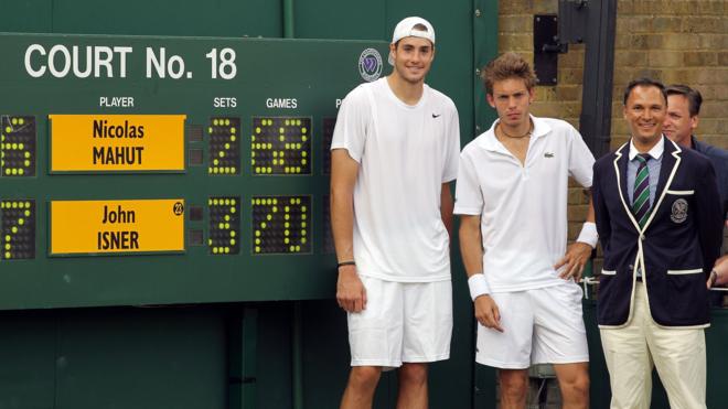 Isner and Mahut pose with the scoreboard after their marathon match at Wimbledon