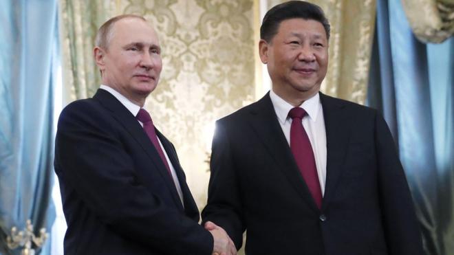 El presidente de Rusia, Vladimir Putin, estrecha la mano de su homólogo chino, Xi Jinping.