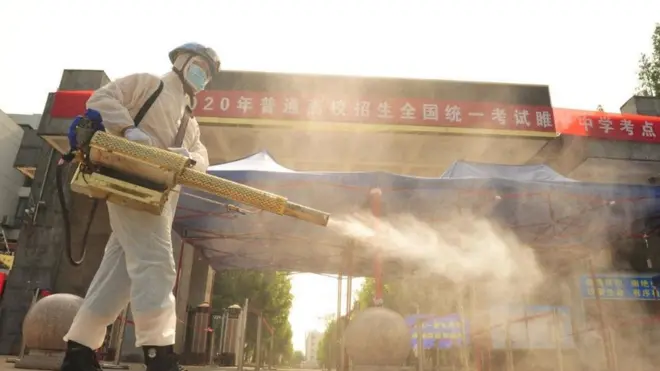 Seorang relawan menyemprotkan cairan desinfektan di sebuah sekolah yang akan mengadakan ujian masuk perguruan tinggi di Kabupaten Suining, provinsi Jiangsu, China (06/07).