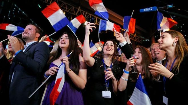 Votantes franceses con banderas de su país.