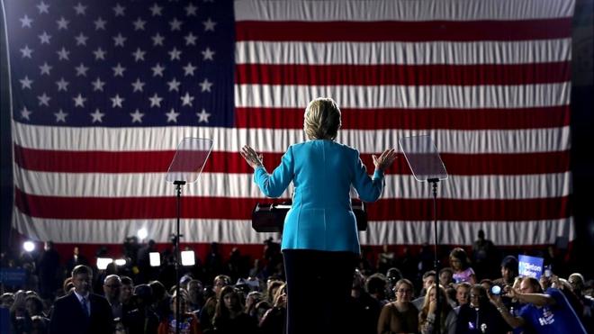 Hillary Clinton de espaldas sobre el escenario en un acto de campaña, 2016.