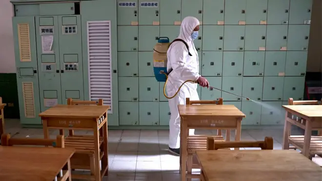 台湾一高中內，医务人员正在教室內进行消毒