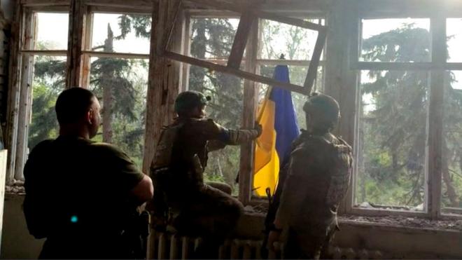 Photo purportedly showing Ukrainian soldiers place a Ukrainian national flag at a destroyed building in the village of Blahodatne, eastern Ukraine. Photo: 11 June 2023