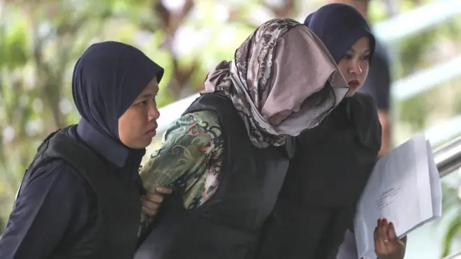 Doan Thi Huong (C) of Vietnam, who was detained in connection with the death of Kim Jong-nam, is escorted by Malaysian police officers