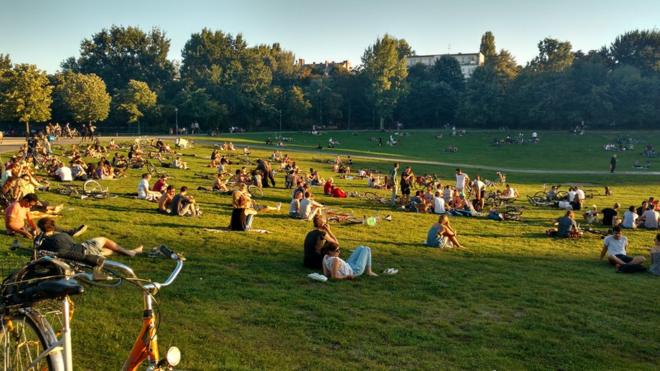 Pessoas tomam sol no parque