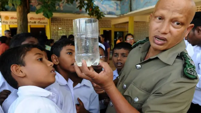 Sri Lankan schoolchildren look at a container holding mosquito larvae, held up by an official, at a school in the Colombo suburb of Wattala on June 29, 2012, during the start of a major clean up operation to tackle the spread of the dengue virus which is transmitted by mosquitoes. Official figures show that 15,000 people were infected with dengue in the first five months of this year compared to 10,300 in the corresponding period last year. AFP PHOTO/Ishara S. KODIKARA (Photo credit should read Ishara S.KODIKARA/AFP/GettyImages)
