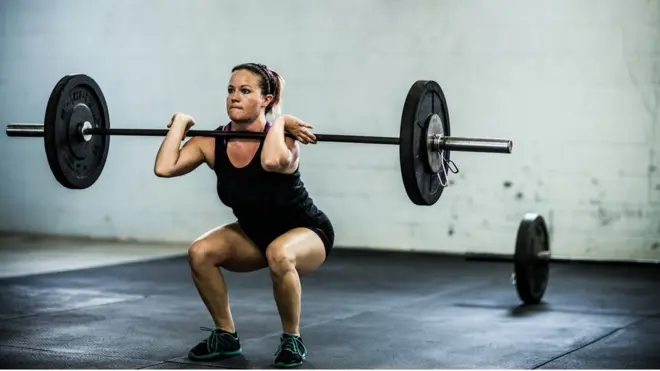 Una mujer levanta pesas