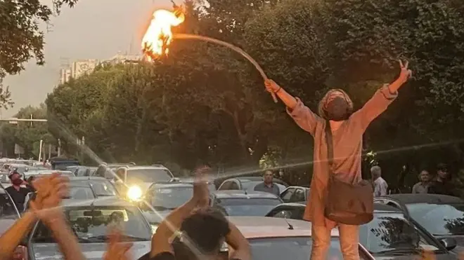 امرأة تشعل النار في حجابها خلال مظاهرة احتجاجية في طهران الاثنين