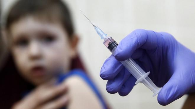 A child is vaccinated for measles and mumps