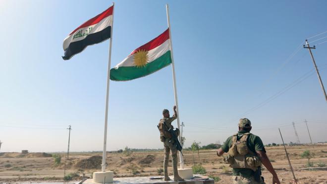 A member of Iraqi security forces takes down the Kurdish flag in Kirkuk, Iraq