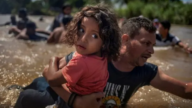 Migrantes cruzando el río Bravo