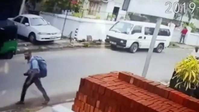 A suspected suicide bomber carries a backpack on a street in Negombo, Sri Lanka