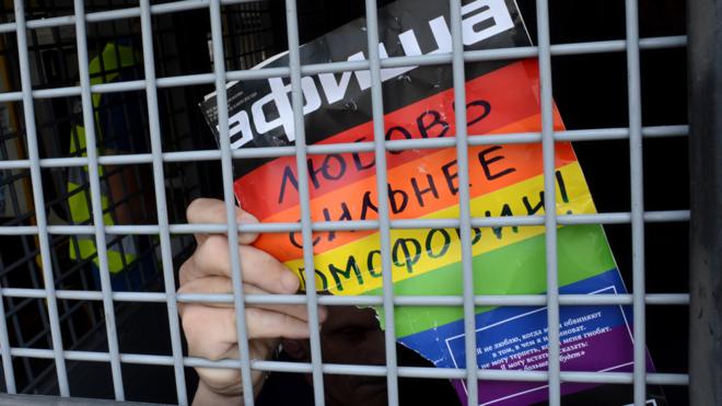 Un activista gay detenido en Moscú con un aviso que lee "el amor es más fuerte que la homofobia".